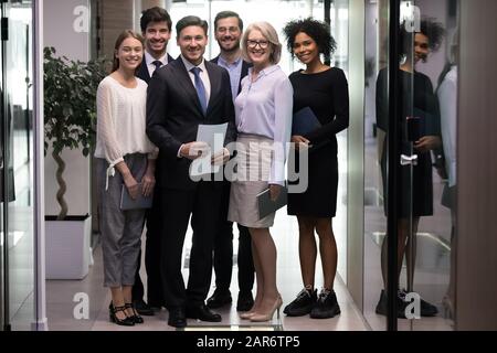 Heureux personnes d'affaires multiraciales plus âgées et plus jeunes regardant l'appareil photo. Banque D'Images