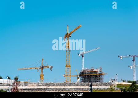 Tower Cranes sur un site de construction contre le ciel bleu Banque D'Images