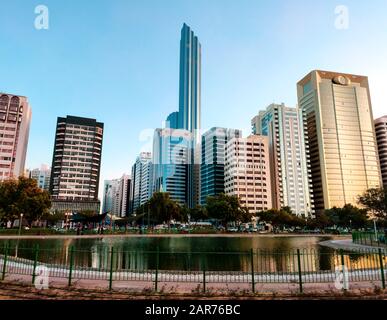 Le paysage urbain du centre-ville d'Abu Dhabi se reflète dans l'eau du parc du lac Banque D'Images