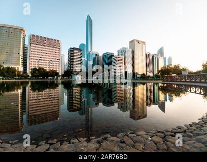 Le paysage urbain du centre-ville d'Abu Dhabi se reflète dans l'eau du parc du lac Banque D'Images