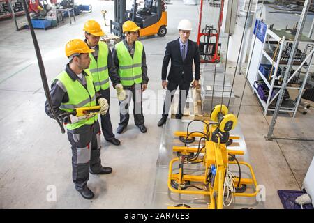 Groupe de travailleurs et d'hommes d'affaires à facroty, électro-aimants permanents pour le levage de plaque d'acier, aimants de levage industriels, charge d'aimant de levage de feuille Banque D'Images