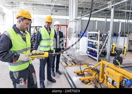 Groupe de travailleurs et d'hommes d'affaires à facroty, électro-aimants permanents pour le levage de plaque d'acier, aimants de levage industriels, charge d'aimant de levage de feuille Banque D'Images