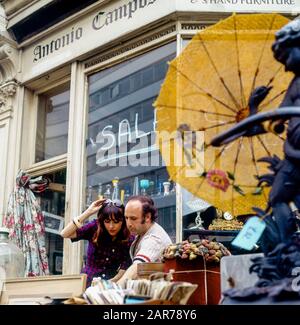 Londres 1970, femme shopping et marchand d'antiquités, rue à l'extérieur de magasin d'exposition, Kensington, Angleterre, Royaume-Uni, GB, Grande-Bretagne, Banque D'Images