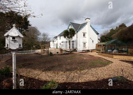 Un jardin en construction en hiver, chemins,pelouse,frontières,arche,dovecote,serre, prêt à planter. Banque D'Images