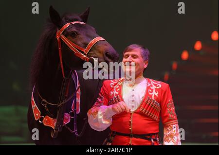 Saint-Pétersbourg, Russie - 27 décembre 2019: Oleg Tandelov et son cheval formé, Orlov trotter Scythian sur l'arène avant la première du spectacle OFU. Atterrissage À Saint-Pétersbourg Banque D'Images