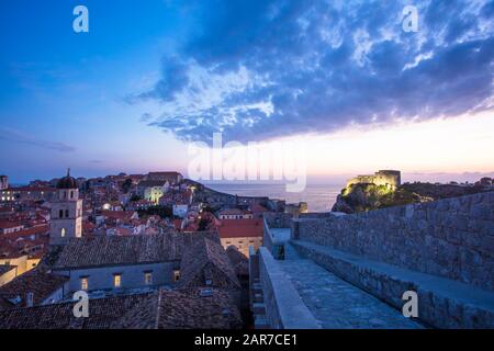 Coucher de soleil de la vieille ville de Dubrovnik depuis le haut des murs de la ville. Sur la gauche se trouve le monastère franciscain et sur la droite le fort Lovrijenac. Banque D'Images