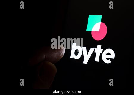 Le logo de l'application BYTE sur l'écran tactile sombre et le doigt lui pointent. BYTE New social media Platform concurrent de TikTok. Banque D'Images