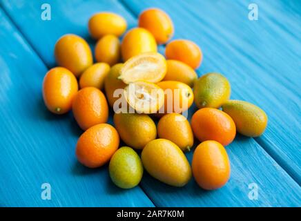 Kumquat sur fond bleu. Agrumes orange brillant Banque D'Images