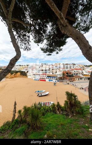 La plage et la ville côtière de Carvoeiro dans la région de l'Algarve au Portugal, les bâtiments colorés et la plage de sable doré. Banque D'Images