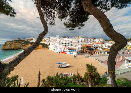 La plage et la ville côtière de Carvoeiro dans la région de l'Algarve au Portugal, les bâtiments colorés et la plage de sable doré. Banque D'Images