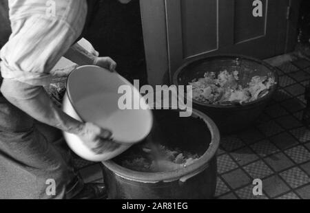 Années 1950, historique, faire de l'hydromel, un homme versant de l'eau chaude dans de grands bols en grès de miel, pour faire l'ancienne boisson alcoolisée hydromel, également connu sous le nom de vin de miel, Angleterre, Royaume-Uni. Banque D'Images