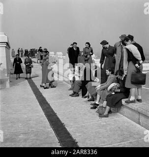 Années 1950, historique, printanière et visiteurs dans les modes de la journée, assis et debout sur le toit en pierre d'un grand bâtiment à Paris, France. Banque D'Images