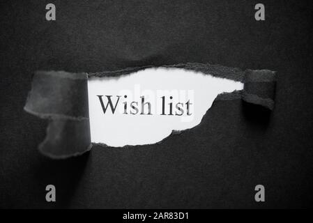 Liste de souhaits de mot imprimée sur un fond blanc avec du papier déchiré noir. Nouvelle année Banque D'Images