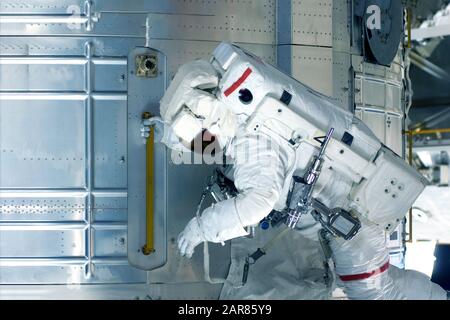 Astronaute dans un espace, vue latérale, sur une station spatiale. Des éléments de cette image ont été fournis par la NASA. À tout usage. Banque D'Images