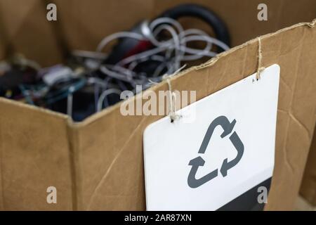 Boîte en carton avec panneau de recyclage de feuilles de papier. Point de collecte des appareils ménagers cassés jetés. Récupération réutilisable des déchets et des déchets Banque D'Images