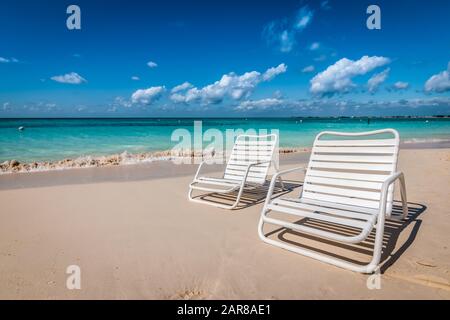 Deux chaises de plage blanches sur Seven Mile Beach à Grand Cayman, aux îles Caïmanes. Banque D'Images
