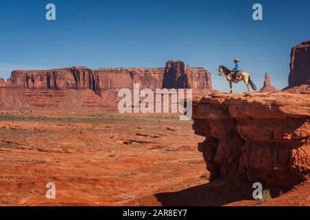 Cowboy monte à cheval au bord d'une falaise à Monument Valley en été, Arizona Banque D'Images