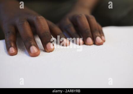 Gros plan sur un homme africain aveugle méconnaissable lisant le livre de braille pendant qu'il étudie à l'école, copier l'espace Banque D'Images