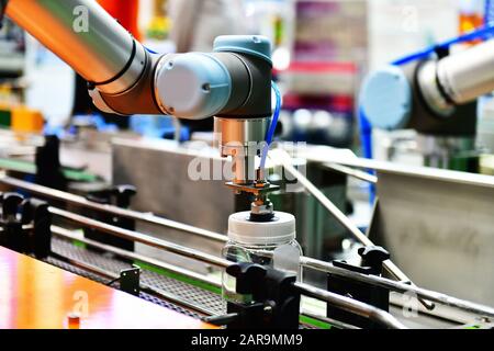 Le bras robot de verre disposés sur la bouteille d'eau dans l'équipement automatique de machines industrielles factory de la ligne de production Banque D'Images