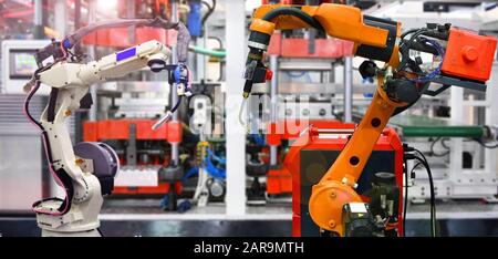 Système de machine-outil manuel robotique orange et blanc en usine, concept de robot industriel Banque D'Images