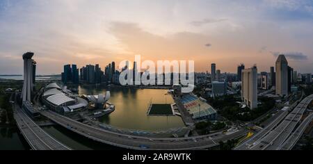 Singapour - 03 novembre 2019: Vue aérienne de la circulation sur une autoroute avec la célèbre ligne d'horizon du quartier des affaires de Singapour pendant le coucher du soleil en arrière-plan Banque D'Images