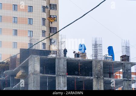 Constructeur sur le site de construction d'une maison en construction. Mise au point douce Banque D'Images