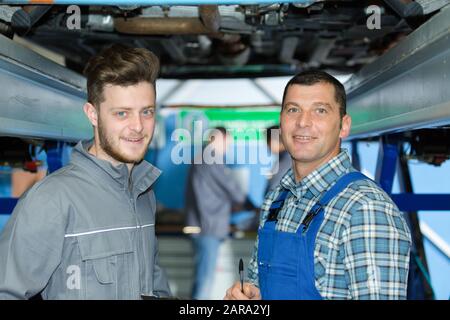 portrait de deux mécaniciens sous la voiture Banque D'Images