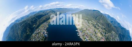 Vue aérienne de l'embouchure dans le lac Teletskoye large dans les montagnes de l'Altaï par l'eau, bleu ciel avec des nuages blancs, vert des arbres sur les pentes de l'un des roches Banque D'Images