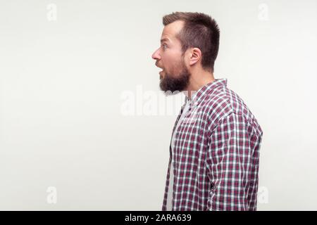 Vue latérale portrait de l'homme barbu étonné dans le maillot de secours debout avec sa bouche ouverte et surpris l'expression choquée sur le visage, difficile à croire, em Banque D'Images