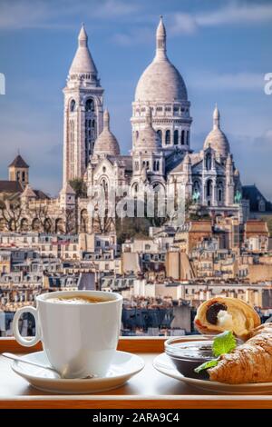 Café parisien avec croissants contre la basilique du Sacré-cœur en France Banque D'Images