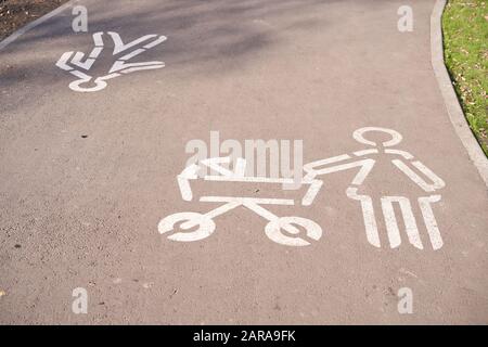 Une route spéciale pour la marche et pour les parents avec un bébé. Signez maman avec une poussette dessinée par la peinture blanche sur la route dans le parc. Banque D'Images