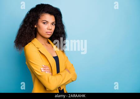 Photo de profil d'une jeune femme d'affaires à peau sombre les mains croisées auto-confiante bossy sérieux travailleur porter un costume de bureau jaune élégant Banque D'Images