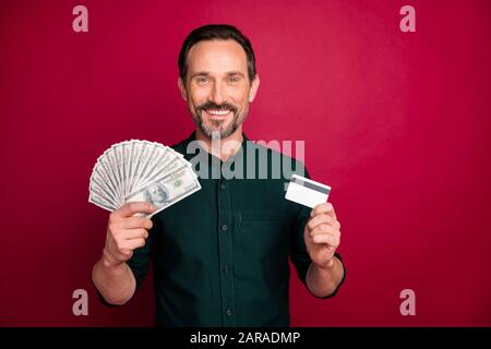 Gros plan portrait de son beau homme à la belle jolie jolie jolie barbe, tenant dans la main pigiste 100 carte en plastique isolée sur brillant vif brillant Banque D'Images
