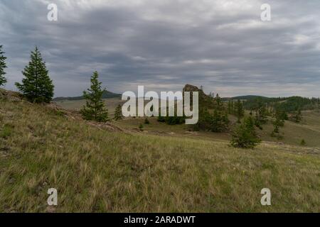 Région de Baikal. Route de terre sur la steppe de Tazheranskaya près des rochers de pierre, appelée la vallée des esprits de pierre. Banque D'Images