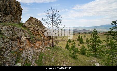 Région de Baikal. Route de terre sur la steppe de Tazheranskaya près des rochers de pierre, appelée la vallée des esprits de pierre. Banque D'Images