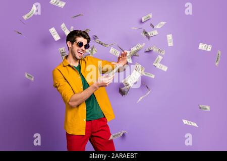 Photo de blanc gai brun habit tendance homme à la mode avec des picots jetant de l'argent avec des émotions folles sur le visage dans le pantalon rouge jaune chemise isolée Banque D'Images