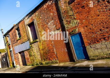 Porte bleue dans l'ancien mur au soleil d'hiver. Banque D'Images