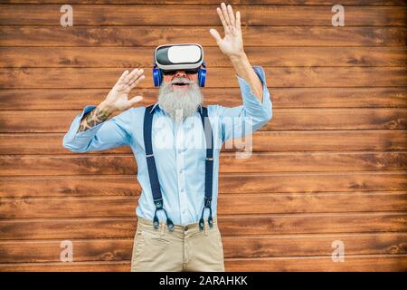 Homme à la mode mûr et amusant grâce à la technologie de lunettes de réalité virtuelle - homme de mode senior portant un casque vr - Tech, style de vie moderne et un vieil joyeux Banque D'Images