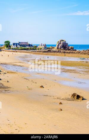 La plage de sable et le petit port de Pors Hir à marée basse dans la municipalité de Plougrescant dans le nord de la Bretagne, France, par une journée d'été ensoleillée. Banque D'Images