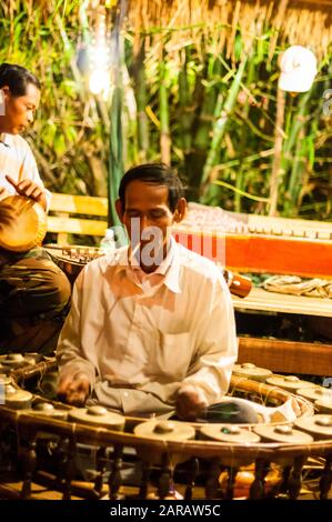 Musiciens de la percussion dans le cadre d'un groupe de musique traditionnelle khmère. L'homme en face joue le kong vong toch (gong) Banque D'Images