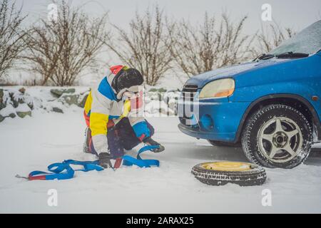 Homme avec crochets de corde de remorquage près de la voiture remorquée Banque D'Images