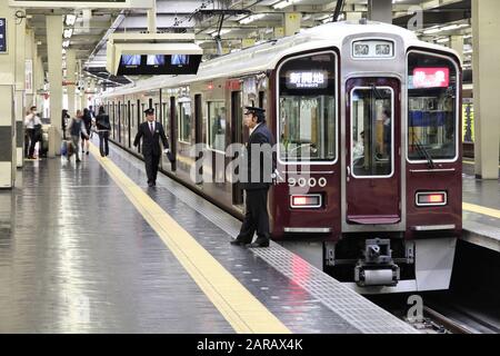 OSAKA, JAPON - 24 avril 2012 : Les hommes conseil train à Osaka station Hankyu Umeda, à Osaka au Japon. Il est le plus actif dans le Japon de l'Ouest station desservant av Banque D'Images