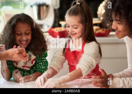 Femme et deux filles préparant des biscuits de Noël Banque D'Images