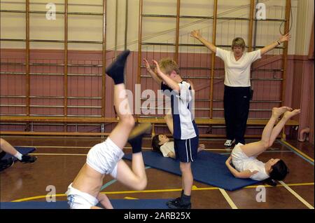 Enfants de l'école primaire faisant de la gymnastique en cours de gymnastique Banque D'Images