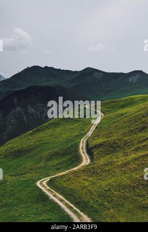 Une piste de sentier traverse le paysage de montagne des terres agricoles vertes de Stoos, Morschach, Schwyz, Suisse UE - Alpes suisses paysage de montagne d'été Banque D'Images