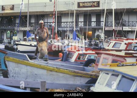 Pêcheur local, bateaux de pêche et café au bord de l'eau, Barbade, Caraïbes. Vers les années 1980 Banque D'Images