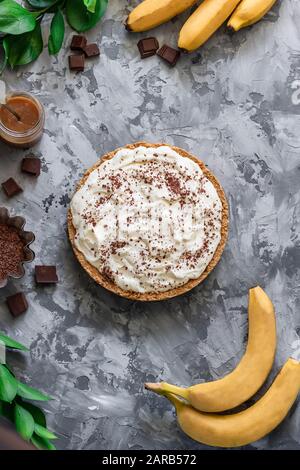 Un dessert traditionnel de bananes. Banoffee pai avec fromage à la crème et chips de chocolat à base de bretzels marinés. Banque D'Images