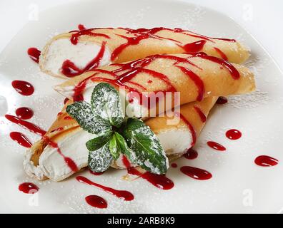 Crêpes françaises avec crème au fromage cottage, décorées de menthe et de sucre en poudre. Banque D'Images