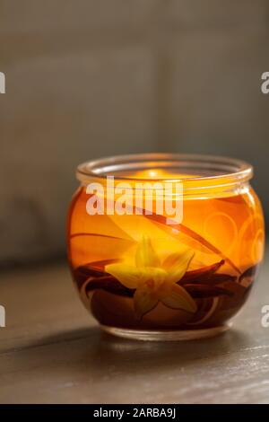 Bougie vanille éclairée dans un pot en verre. Foyer sélectif avec faible profondeur de champ. Banque D'Images