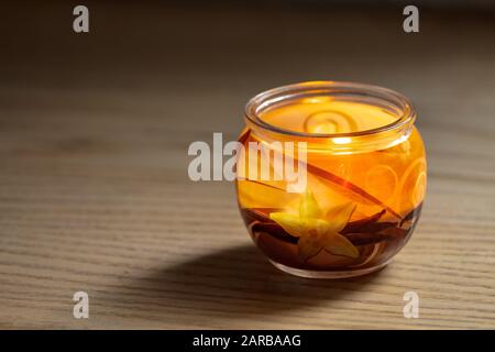 Bougie vanille éclairée dans un pot en verre. Foyer sélectif avec faible profondeur de champ. Banque D'Images